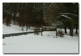 The Tom Jenkins Dam sign in a field of snow-- click to enlarge