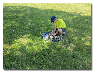 Len working with his station on the grassy field