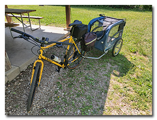 A yellow bicycle with a dog-trailer