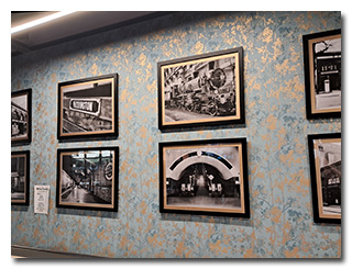 a wall of photographs of London's Paddington Station and British steam trains